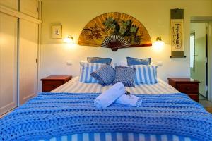 a large blue and white bed with blue pillows at The Olives Heritage House in Yankalilla +31 photos