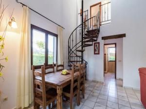 a dining room with a wooden table and a spiral staircase at Scenic Bungalow Retreat in Pozo Alcon in Cuenca