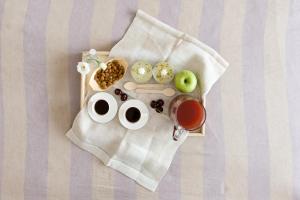 a tray of food with two cups of tea and apples at Dimore Romano in Lecce +42 photos