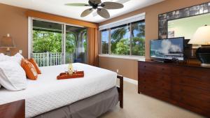 a bedroom with a bed and a flat screen tv at SUMMER BREEZE Sunny 2BR Kulalani Home Next To Community Pool in Waikoloa