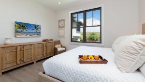 a bedroom with a bed with a wooden dresser and a window at MAUNA KEA BEACH ESCAPE Luxurious home in private community with Heated Private Pool and Spa Detached Ohana Suite in Waimea +90 photos