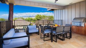 a dining room with a table and chairs on a balcony at SAND CASTLE Modern KaMilo 4BR Home with Ocean Views Bikes in Waikoloa