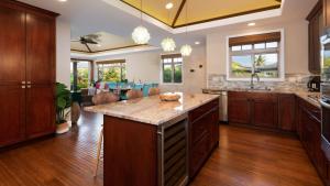 ワイコロアにあるKOHALA HAVEN Heavenly 3BR KaMilo Home Closest to Pool Complexの木製のキャビネットと大きな島付きのキッチン