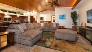 a living room with a large couch and a kitchen at SUNSET VILLA Spacious Mauna Lani 3BR Home With Private Beach Club in Waikoloa