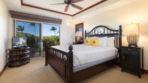 a bedroom with a bed and a tv and a window at SUNSET VILLA Spacious Mauna Lani 3BR Home With Private Beach Club in Waikoloa +50 photos