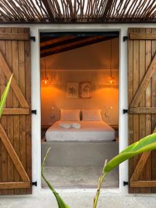 a bedroom with a bed in a room with wooden doors at Bibi in La Trinité