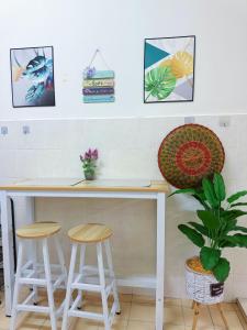 a counter with stools and pictures on the wall at Sri Ixora Kajang Fully Air Con Suite in Kajang +16 photos