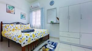 a bedroom with a bed with a yellow and white comforter at Sri Ixora Kajang Fully Air Con Suite in Kajang