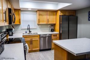 サウス・パドレ・アイランドにあるBEACHVIEW 110 condoのキッチン(木製キャビネット、ステンレス製の冷蔵庫付)