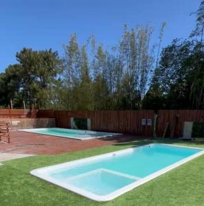 インビトゥバにあるPousada Encantos do Rosaの木製の柵の隣の庭にあるスイミングプール