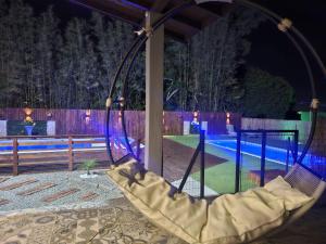 a swing in a yard with a pool at night at Pousada Encantos do Rosa in Imbituba