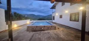 a swimming pool in the middle of a house at night at Finca El Paraíso in Villeta