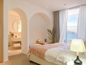 a bedroom with a bed and a large window at Shenzhen White House Nan'ao Beach Seaview guesthouse in Youcaopeng