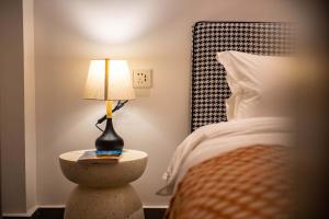 a bedroom with a bed and a lamp on a table at Shenzhen White House Nan'ao Beach Seaview guesthouse in Youcaopeng +180 photos