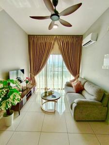 een woonkamer met een bank en een plafondventilator bij The Horizon Ipoh Emerald by Grab A Stay in Ipoh