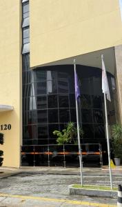 two flags are in front of a building at Flat 502 América Tower, ao lado do Salvador Shopping in Salvador +1 photo
