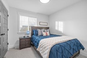 une chambre avec un lit bleu et une fenêtre dans l'établissement Peaceful Idaho Falls Stay Fire Table Sleeps 8, à Idaho Falls