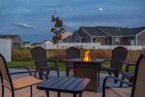 d'une terrasse avec des chaises et une table avec un foyer extérieur. dans l'établissement Peaceful Idaho Falls Stay Fire Table Sleeps 8, à Idaho Falls