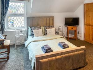 a bedroom with a large bed with two towels on it at Sherwood House Apartment 3 in Bakewell