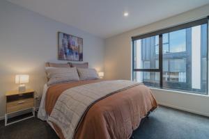 a bedroom with a bed and a large window at Modern Addington Escape Stylish 2br Townhouse in Addington