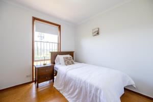 Una habitación blanca con una cama y una ventana en The Valley View Guest House, en Melbourne
