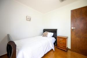 1 dormitorio con 1 cama, vestidor y puerta en The Valley View Guest House, en Melbourne