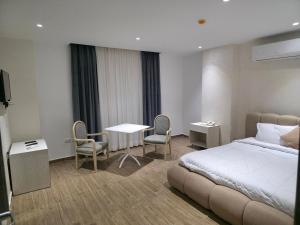 a hotel room with a bed and a table and chairs at Giza City Hotel-الجيزة سيتى اوتيل in Cairo