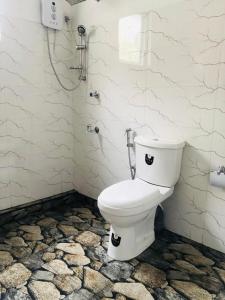 a bathroom with a toilet with black eyes on it at Gam Maduwa , cooking class and Tours in Nuwara Eliya +43 photos