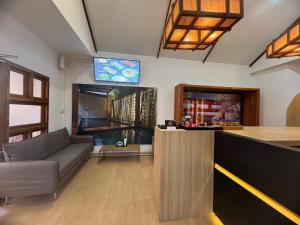 soggiorno con divano e bar di Nozawa Hostel and Onsen - Men Only a Chiang Mai