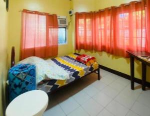 Cette chambre comprend un lit avec des rideaux rouges et des toilettes. dans l'établissement Namaste Olango Guesthouse by Hiverooms, à Sampong