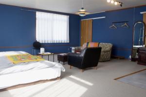 1 dormitorio con paredes azules, 1 cama y 1 silla en Machicado, en Tamano 68 fotos más