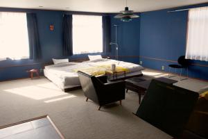 ein Schlafzimmer mit einem Bett, einem Tisch und Stühlen in der Unterkunft Machicado in Tamano