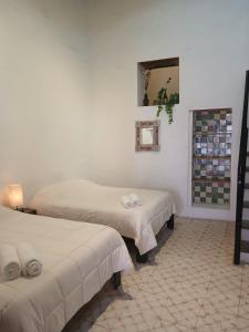 two beds in a room with white walls at Casa Posada Rústica - A 1 minuto del Jardín Unión in Guanajuato