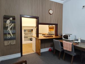 a room with a desk and a table with a microwave at Kaivalya Niketan in Perth