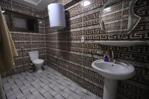 a bathroom with a sink and a mirror and a toilet at Giza City Hotel-الجيزة سيتى اوتيل in Cairo +116 photos