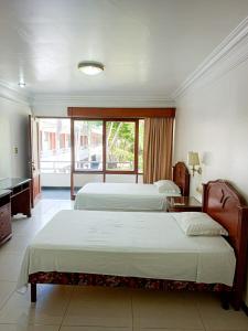 a hotel room with two beds and a balcony at Ex Hotel Asturias Centrico in Santa Cruz de la Sierra