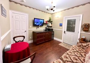 a living room with a table and a television at Barker House 3# Suite-heart of oldtown in Niagara on the Lake