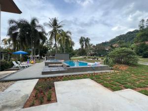 a backyard with a swimming pool and a garden at Theorenda house in Ban Taling Ngam +6 photos