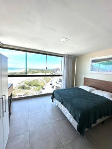 une chambre avec un lit et une grande fenêtre dans l'établissement Eu Amo Arraial Hospedagem - Studio Sophia I Vista Mar, à Arraial do Cabo 43 autres photos