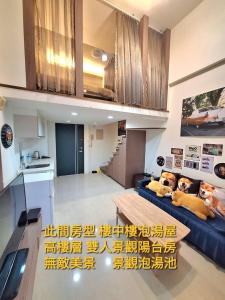 un soggiorno con un divano blu e un tavolo di Golden Wing樓中樓溫泉宿 a Jiaoxi