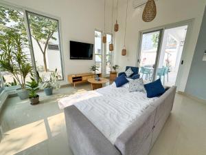 a large bed with blue pillows in a room with windows at Casa Atara in Flores