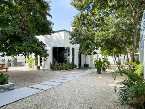 a white house with trees and a gravel driveway at Casa Atara in Flores