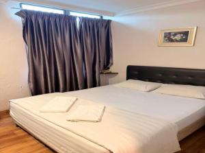 ニライにあるSwing & Pillows - Dataran Nilaiの窓のある大きな白いベッドのある寝室