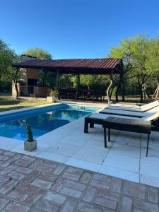 a swimming pool with a gazebo and a table next to it at Cabañas Refugio Lavanda in Villa de Las Rosas