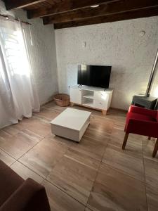 a living room with a flat screen tv and a couch at Cabañas Refugio Lavanda in Villa de Las Rosas
