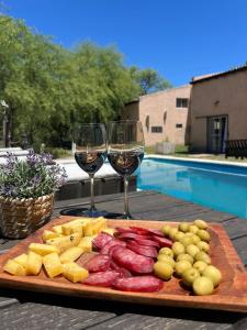 a plate of food and two glasses of wine at Cabañas Refugio Lavanda in Villa de Las Rosas