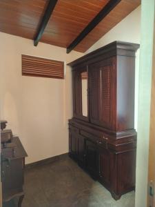 a large wooden cabinet in a room with a desk at The windsor Retreat in Moratuwa
