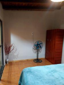a bedroom with a bed and a fan and a dresser at La casa de las flores in Las Heras