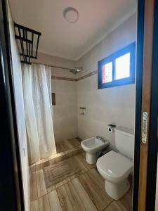 un baño con inodoro y lavabo en Refugio Serrano, en Merlo