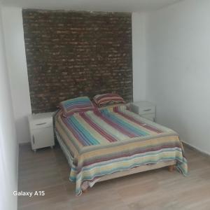 a bed in a bedroom with a brick wall at Doña Antonia in Albarellos